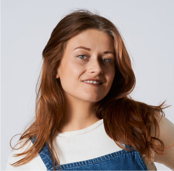 Portrait of a man with brown hair and glasses on a flat gray background.